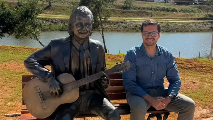 fernando breno ao lado da estátua do compositor Goiá